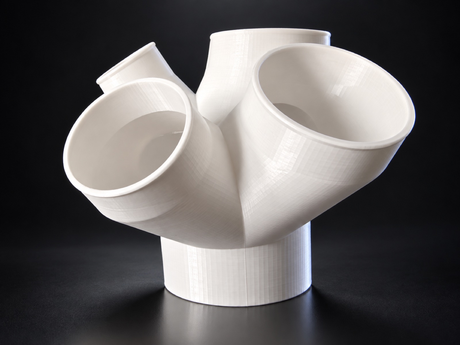 Large custom white 3D printed branching duct on a dark studio background